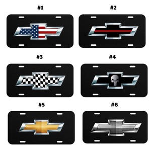 May include: Six rectangular black license plates featuring the Chevrolet bowtie logo. Designs include the American flag, a thin red line, a black and white checkered pattern, a skull emblem, a gold finish, and a silver metallic grid texture.