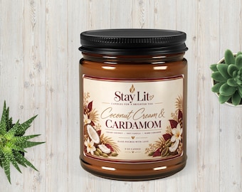 May include: A 9 oz candle in a brown glass jar with a black lid. The label features the text Stay Lit, Coconut Cream & CARDAMOM, Creamy Coconut, Soft Vanilla, Warm Cardamom, and Hand Poured With Love, decorated with illustrations of coconut and flowers.