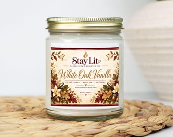 May include: A 9 oz candle in a clear glass jar with a gold metal lid. The label features the text Stay Lit, White Oak Vanilla, Creamy Vanilla, White Oak, Soft Smoke, and Hand Poured With Love, decorated with illustrations of autumn leaves and acorns.