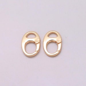 May include: Two gold-toned oval-shaped lobster claw clasps with a smooth, polished finish. Each clasp features a spring-loaded mechanism on one side, designed for secure attachment in jewelry making or other craft projects.