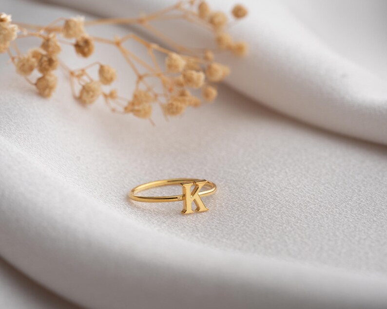 Script initial ring featuring a personalized ring with a custom initial in a minimalist handwriting style