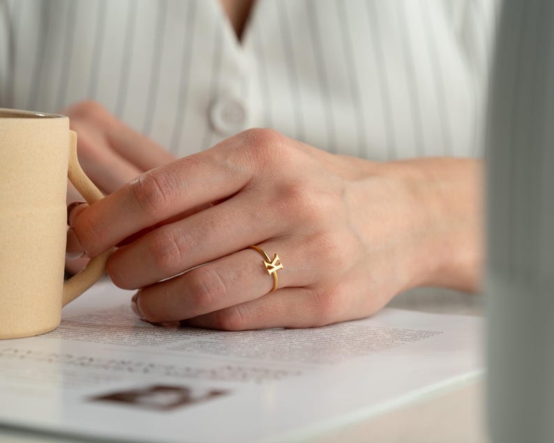 Custom initial ring worn on hand featuring a dainty ring for everyday jewelry wear