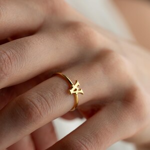 Personalized ring worn on hand featuring a script initial ring with a custom initial and modern jewelry style