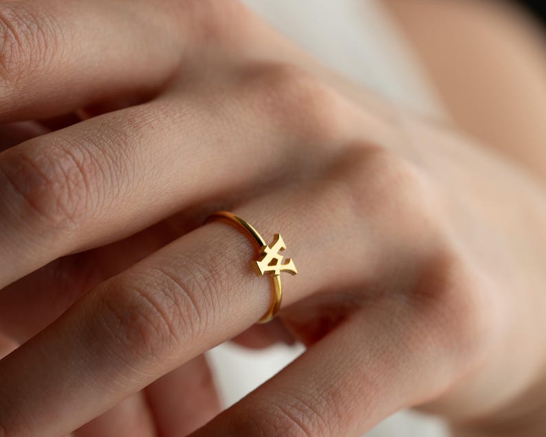 Personalized ring worn on hand featuring a script initial ring with a custom initial and modern jewelry style