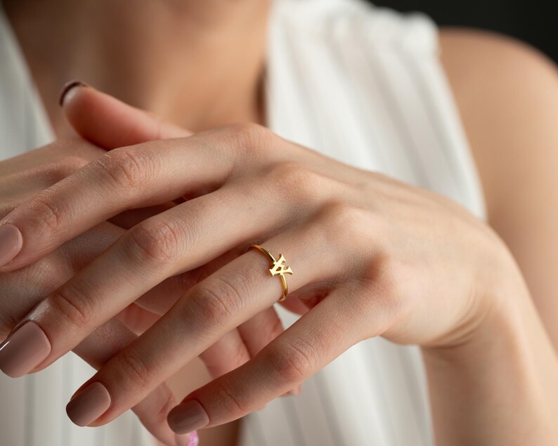 Personalized script initial ring worn on model featuring a custom initial ring, minimalist ring, and modern jewelry style
