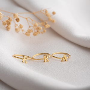 Script initial rings displayed together highlighting letter ring designs with personalized jewelry styling