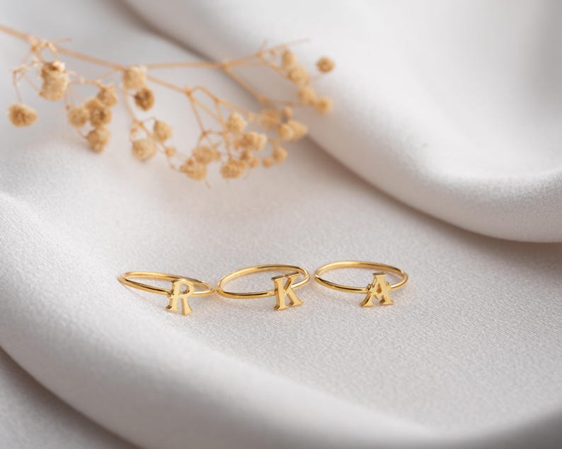Script initial rings displayed together highlighting letter ring designs with personalized jewelry styling