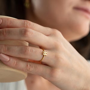 Personalized jewelry worn on model featuring a script initial ring with a custom initial design