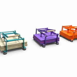 May include: Three colorful, wooden book presses. One is teal with a light wood handle, another is purple, and the third is orange. Each press has a wooden handle and sits on four small, round feet. The presses are on a white background.