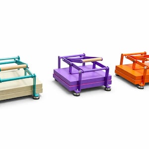 May include: Three colorful book presses in teal, purple, and orange. Each press has a wooden handle and a base with a stack of wooden boards. The presses are on a white background.