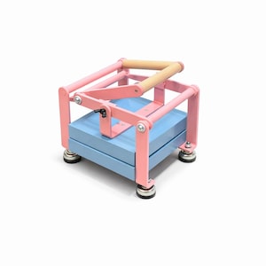 May include: A pink and blue press with a wooden handle. The press has a light blue base and pink metal frame. The handle is made of light-colored wood. The press sits on four small, round feet.