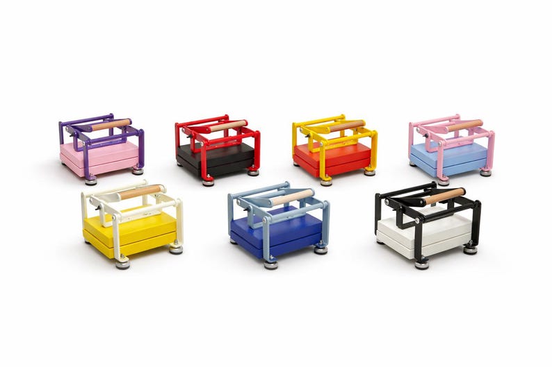 May include: A collection of colorful, miniature presses. Each press features a rectangular base and a frame with a wooden handle. The presses are in various colors, including purple, red, yellow, pink, white, blue, and black.