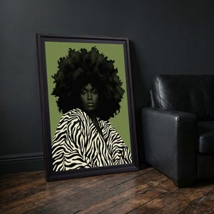 May include: A framed wall art print featuring a portrait of a person with a large afro hairstyle wearing a black and white zebra-striped garment against a solid olive green background. The artwork is enclosed in a dark brown rectangular frame.