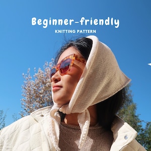 Puede incluir: Un pañuelo de punto color crema atado bajo la barbilla, usado con gafas de sol de carey y una chaqueta acolchada. El texto "Beginner-friendly KNITTING PATTERN" aparece en blanco sobre un fondo de cielo azul despejado.