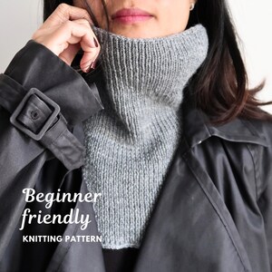 May include: A grey knitted turtleneck dickey worn under a black trench coat. The text on the image reads Beginner friendly KNITTING PATTERN. The knitted accessory features a ribbed collar and a smooth knit chest panel covering the neck area.