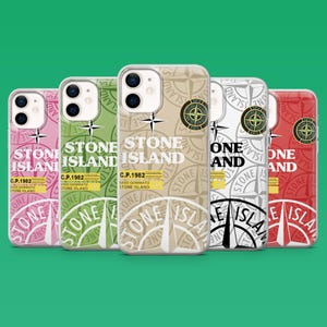 Op de afbeelding: Vijf smartphonehoesjes op een rij, elk met een herhalend kompasroospatroon, de tekst STONE ISLAND en C.P. 1982 RASO GOMMATO STONE ISLAND. De hoesjes zijn roze, lichtgroen, beige, wit en rood van kleur, met een ronde logopatch.