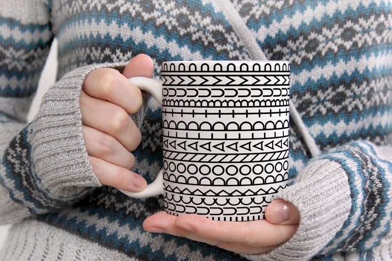 May include: A white ceramic mug featuring a repeating black graphic pattern of horizontal bands. The design consists of various geometric shapes including circles, triangles, semicircles, and lines arranged in distinct rows around the exterior surface.