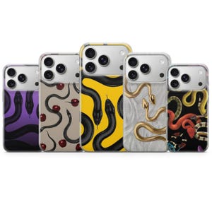 Puede incluir: Cinco fundas para smartphone dispuestas en fila, cada una con un diseño de serpiente distinto. Los patrones incluyen serpientes negras sobre morado, serpientes negras con manzanas rojas sobre beige, serpientes negras sobre amarillo, doradas sobre gris y coloridas sobre negro.