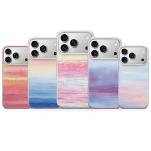 Può includere: Cinque cover per smartphone disposte in fila, ognuna caratterizzata da un motivo sfumato in stile acquerello unico. I design includono tonalità arancione, blu, rosa, viola e miscele multicolori pastello, tutte con ritaglio per fotocamera.