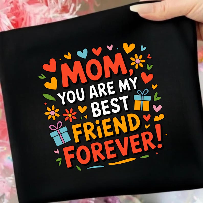 May include: A black fabric item featuring a colorful graphic print with the text MOM, YOU ARE MY BEST FRIEND FOREVER! The design includes orange, yellow, red, and blue hearts, small flowers, and two gift boxes with ribbons in blue and orange.