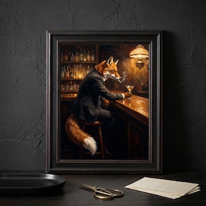 May include: A framed wall art print depicting a fox with orange and white fur wearing a black suit, sitting at a wooden bar counter. The fox holds a cocktail glass and has a cigarette in its mouth. Shelves with bottles are visible in the background.