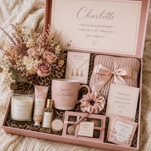 May include: A pink gift box containing a dried flower bouquet, a rose quartz necklace, a pink mug with the text you're one of a kind, a pink candle, hand cream, perfume, a pink scrunchie, a knit item, chocolates, and chamomile and rose tea.