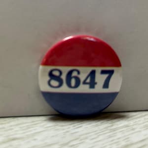 May include: A red, white, and blue button with the number 8647 printed in blue.