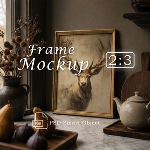 May include: A gold-toned rectangular picture frame containing an illustration of a deer with large antlers. The text "Frame Mockup" and "2:3" appear over the image, along with a "PSD Smart Object" icon. The frame sits near a dark vase.