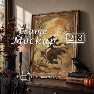 May include: A rectangular gold-toned ornate picture frame containing an illustration of a figure on a bicycle against a large moon. The image features the text Frame Mockup 2:3 and PSD Smart Object. The frame sits on a dark wooden surface.