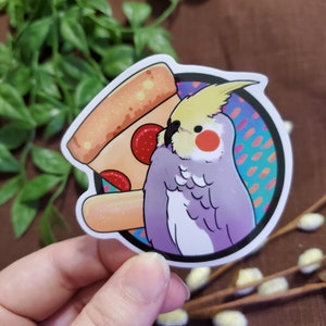 May include: A sticker featuring a cartoon illustration of a cockatiel bird with yellow and white feathers, a purple body, and a red cheek. The bird is holding a slice of pizza with pepperoni and a white crust. The sticker has a colorful background with a blue, orange, and white pattern.