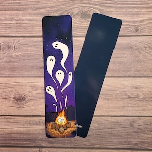 May include: A purple bookmark with a campfire and five white ghosts rising from the flames against a starry night sky. The bookmark has the text "ck.com" at the bottom.