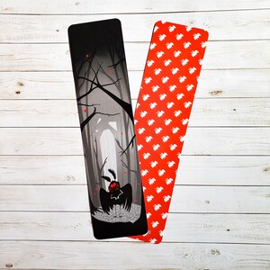 May include: Two bookmarks, one with a black and white illustration of a moth in a forest and the other with a red background and white repeating pattern of a bird.