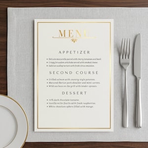 Puede incluir: Una tarjeta de menú rectangular blanca con un borde de lámina dorada y la palabra MENU en oro en la parte superior. El texto enumera aperitivos, segundos platos y postres en fuente negra. Un tenedor y un cuchillo de plata están a la derecha.