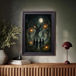 May include: A framed wall art print depicting a dark, enchanted forest scene at night under a full moon. Four figures wearing pointed hats stand on a path surrounded by gnarled trees, glowing lanterns, and a distant stone tower in the background.