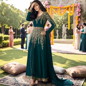 May include: A floor-length dark teal gown featuring long sleeves and a high neckline, adorned with intricate gold floral embroidery across the bodice, waist, and cuffs. The dress includes a central front slit and a flowing skirt with gold trim.