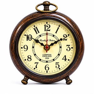 Könnte beinhalten: Eine runde Uhr im Vintage-Stil mit cremefarbenem Zifferblatt und schwarzen römischen Ziffern. Die Uhr hat einen dunkelbraunen, strukturierten Rahmen und einen kleinen Messingring oben. Der Text "Huntleigh Station" und "Cambridge England 1924" sind sichtbar.