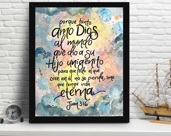 May include: A framed watercolor painting with a colorful background and white text. The text reads "porque tanto amo Dios al mundo que dio a su Hijo unigenito para que todo el que cree en él no se pierda, sino que tenga vida eterna Juan 3:16".