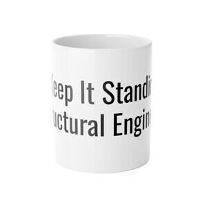 Peut inclure: Mug en céramique blanche avec le texte "Keep It Standing Structural Engineering" en noir et gris. Le mug est cylindrique et a une finition brillante, adapté aux boissons chaudes ou froides.