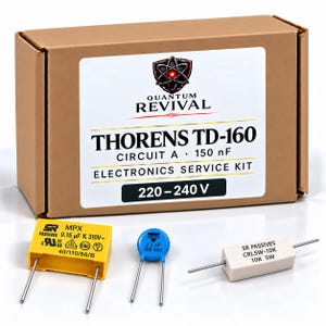 Op de afbeelding: Een bruine kartonnen doos met het label Quantum Revival Thorens TD-160 Circuit A 150 nF Electronics Service Kit 220-240 V. Inbegrepen zijn een gele rechthoekige condensator, een kleine blauwe schijfcondensator en een witte cilindrische weerstand.