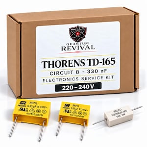 Könnte beinhalten: Ein brauner Pappkarton mit der Aufschrift Quantum Revival Thorens TD-165 Circuit B 330 nF Electronics Service Kit 220-240 V. Vorne liegen zwei gelbe rechteckige Kondensatoren mit 0.33 uF und 0.01 uF sowie ein weißer Yageo 5K6 5W Widerstand.