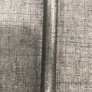 May include: A close-up of a metal rod with a textured, silvery-gray finish. The rod is vertically oriented against a gray, textured background. The surface of the rod appears to have a slightly rough, industrial appearance.