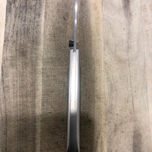 May include: A stainless steel knife with a silver handle and a thin, sharp blade. The knife is designed for precision cutting and is suitable for various culinary tasks. The blade is approximately 20 cm long.
