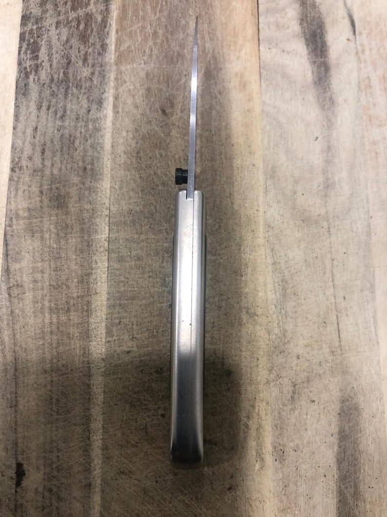 May include: A stainless steel knife with a silver handle and a thin, sharp blade. The knife is designed for precision cutting and is suitable for various culinary tasks. The blade is approximately 20 cm long.