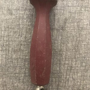 Pode incluir: Uma haste de afiar com um cabo vermelho escuro e um la&ccedil;o de metal prateado na extremidade. O cabo tem um design facetado. A haste de afiar &eacute; usada para manter a nitidez das facas.