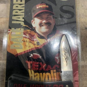 Könnte beinhalten: Ein Sammler-Taschenmesser mit Dale Jarrett, mit dem Text "DALE JARRETT 28" auf dem Griff. Die Messerklinge hat ein Autogramm und den Text "USA". Die Verpackung enthält das "CASE"-Logo und das Branding "TEXACO Havoline".