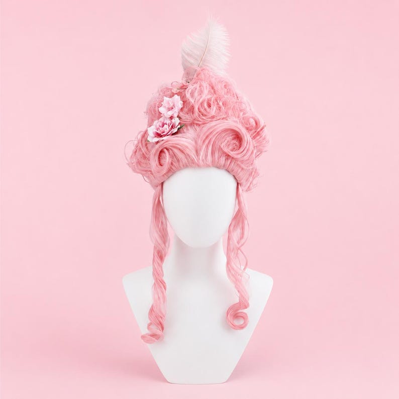 May include: A pink wig in a bouffant style, decorated with a white feather and two pink fabric flowers. The wig is displayed on a white mannequin head against a pink background. The wig has long, curled side pieces.