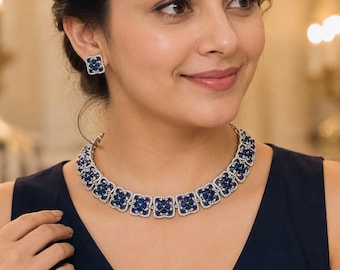 Peut inclure: Un ensemble composé d'un collier et de boucles d'oreilles assorties avec des maillons carrés. Chaque maillon présente un groupe de pierres bleu foncé entouré d'une bordure de petites pierres blanches claires sur une monture argentée.