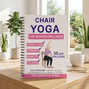 May include: A spiral-bound book titled "CHAIR YOGA" with the subtitle "FOR SENIORS WELLNESS." The cover features an illustration of a senior doing chair yoga, with text highlighting benefits like weight loss and mobility. A white mug and glasses are on the table.