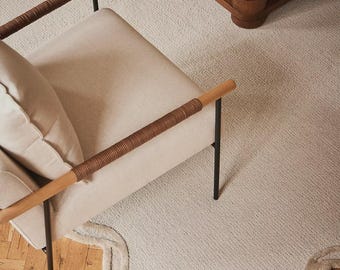 Tapis en laine fait main à bords festonnés, couleur crème beige, design moderne et minimaliste