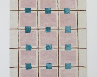 Tapis en laine fait main aux motifs géométriques pastel, décor à carreaux rose poudré